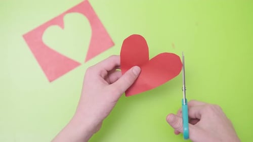 Cutting Red Paper for Valentine Card on Green Background Valentine's Day February 14Th Love Emotions