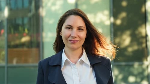 Confident Business Woman Standing Against the Office Building and Smiling