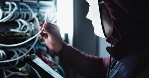 Cyberattaque et pirate masqués avec un smartphone dans une salle de contrôle sombre avec un ransomware pour pare-feu