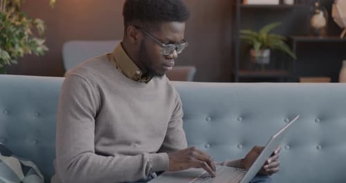 Young Adult Typing on Laptop at Home