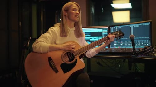 Pretty Woman Playing Guitar and Singing in Studio of Record Label Portrait Audition in Recording