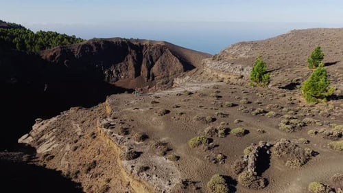 Aerial View Showing Hikers Trekking Rocky Volcanic Path Across Dramatic La Palma Landscape