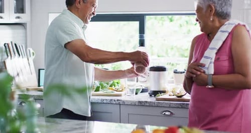 Senior Couple Preparing Healthy Drink Together in Kitchen