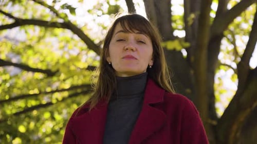 An Attractive Middleaged Caucasian Woman Talks to the Camera with a Smile in a Park Closeup