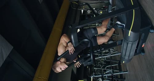 Male Athlete Performing Inverted Exercises on Modern Gym Equipment