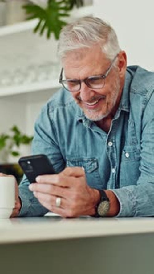 Smiling Man Looking at Phone at Home