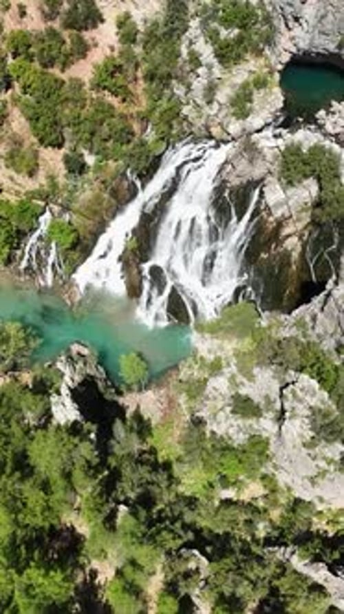 Vídeo vertical Cinemática: Fondo de imágenes aéreas de una hermosa cascada con un impresionante primer plano