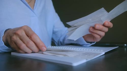 Accountant Checking Receipts and Invoices for Monthly Expense Report