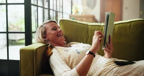 Woman Relaxing on Couch Using Tablet at Home