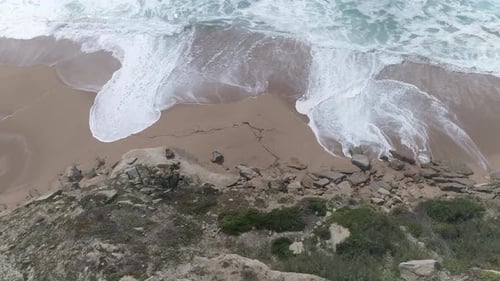 Flight over of rocky coastline. Aerial of Ocean shore, waves crashing cliffs