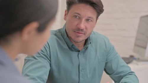 Close up of Middle Aged Man Talking with Teammate