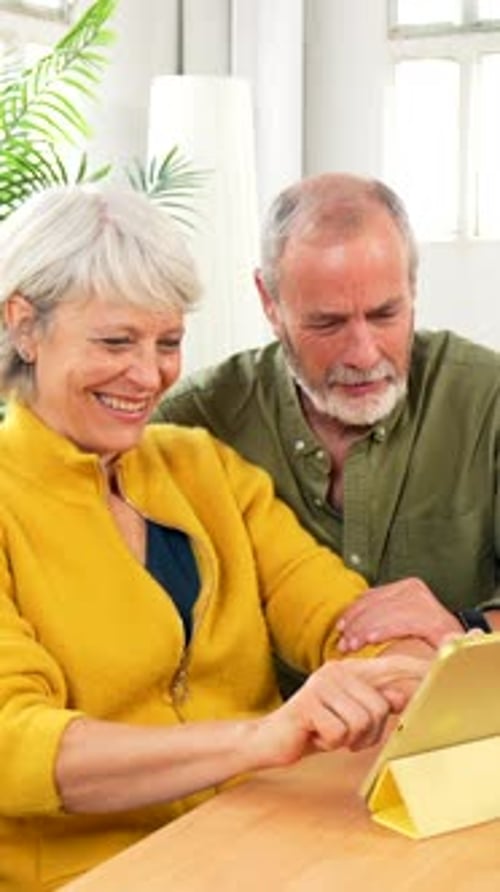 Senior Couple Using Tablet Device Together Indoors