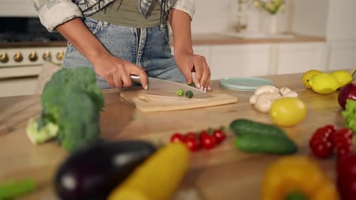Woman Slices Cucumber in Bright Kitchen