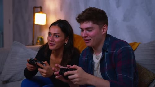 Friends Playing Video Games Together at Home on Couch