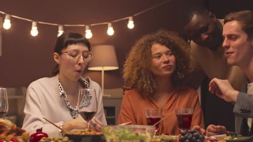 Friends Enjoying Dinner Together, Laughing and Talking