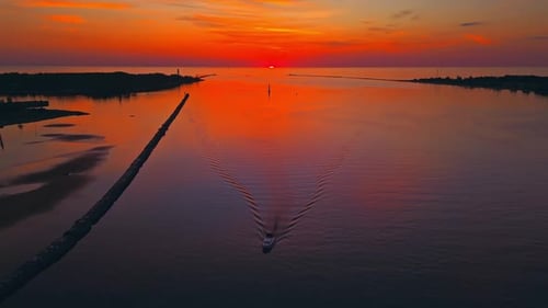 A Stunning Sunrise Reflects on a Tranquil River with a Boat Embodying Serene Tranquility and the