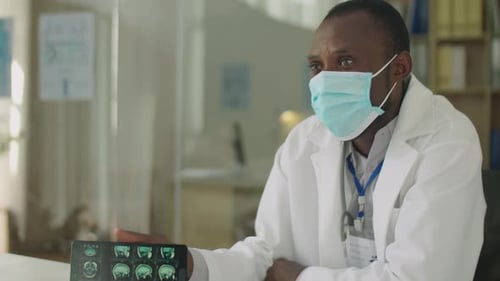 Black Doctor in Face Mask Telling about CT Scan to Patient