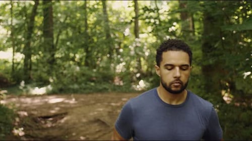 Young man runs through trail in forest