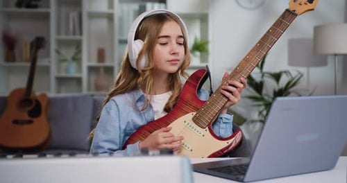 Young Girl Plays Electric Guitar at Home