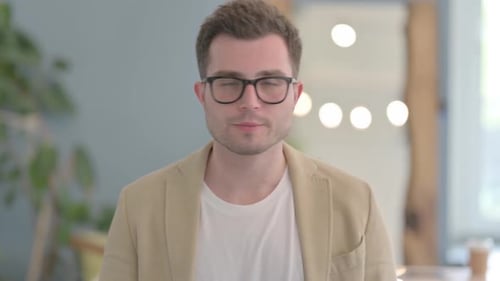 Young Adult Man Wearing Glasses and Tan Jacket