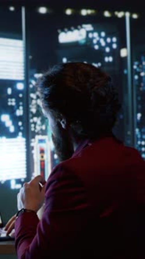 Man Typing on Laptop in Dark Urban Office