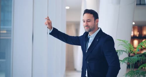 Thoughtful European businessman checking wrist watch and reflecting in office lobby