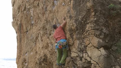 A Man is Climbing a Rock Wall