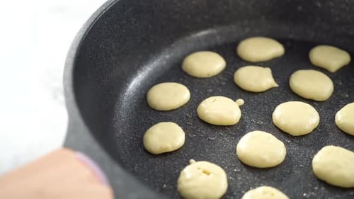 Schritt für Schritt Mini-Pfannkuchen-Müsli in einer antihaftbeschichteten Pfanne braten