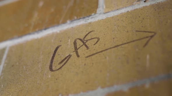 Gas Line Marker Sign With Arrow Written On Brick Wall. Follow Shot, Low ...