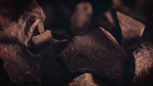 Chunks of sweet dark sliding backdrop, close-up. Gourmet dessert ingredient.