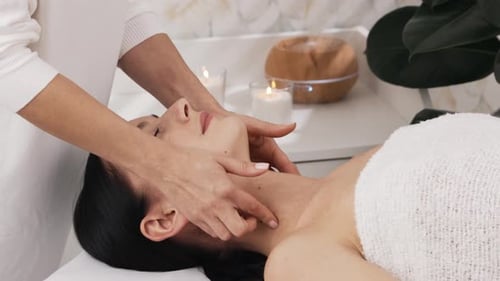 Woman Receiving a Relaxing Face Massage at Spa