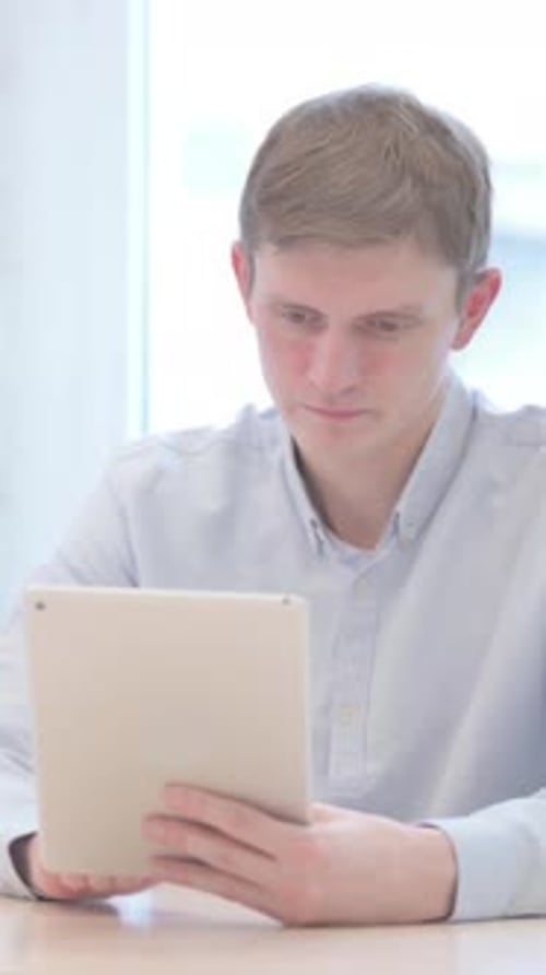 Young Man Using Tablet Device Indoors During Daytime