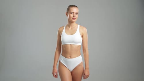 Woman Posing in White Underwear in Bright Studio