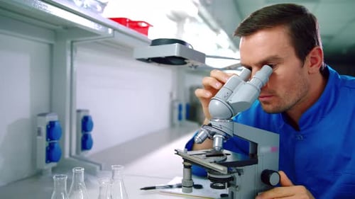 Man Using Microscope for Scientific Research in Lab