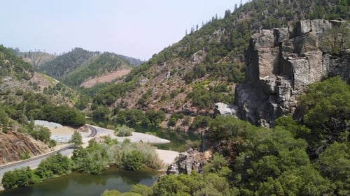 Aerial ascending pan of a river canyon road at 23.976 frames per second