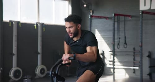 Man, workout and exercise bike in gym for fitness, training and health with cardiovascular benefits