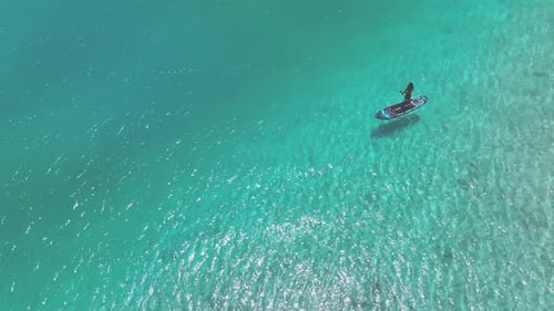 Aerial view of standup paddler in turquoise waters, Maldives.