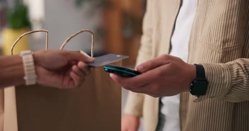 Man Makes Contactless Payment with Credit Card and Phone