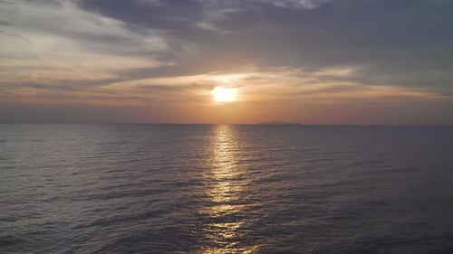 Dramatic sea sunrise. Burning sky and shining golden waves. Evening sunset over ocean. Reflection of