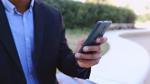 Close Up of Young Business Man Using Smart Mobile Phone Outdoors