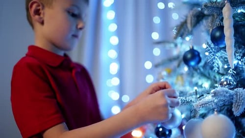 Child Decorating Christmas Tree with Festive Ornaments