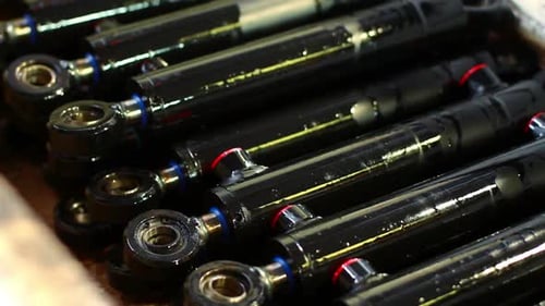 Master Adds Black Shock Absorbers in a Row/Stack of Automobile Parts/Closeup Of