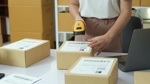 Young Adult Scanning Shipping Labels on Packages