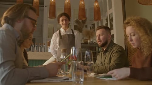Friends Dining Out at a Restaurant, Looking at Menus