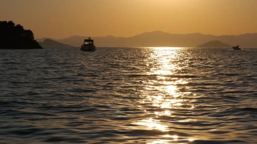 Golden Sunset Reflecting off Calm Ocean with Boats