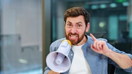 Angry Businessman Yelling Through Megaphone In Office Pointing Finger