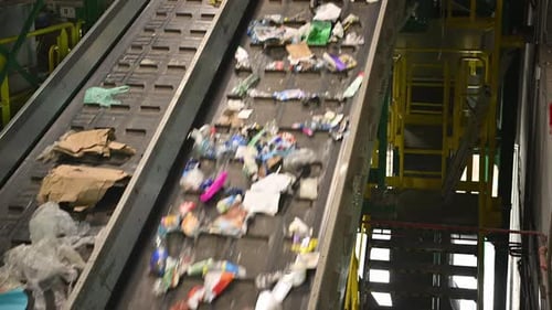Sorting Waste at a Recycling Plant in the Afternoon With Conveyor Belts and Various Materials