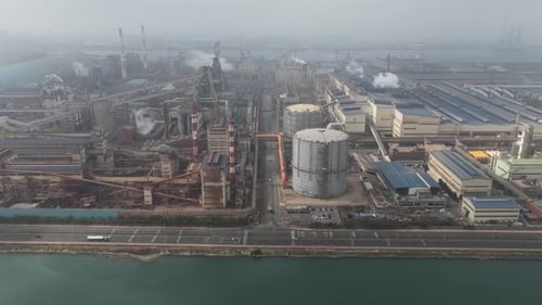 Industrial steel plant emitting smoke aerial view