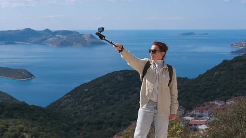 Woman Hiker Vlogging with Action Camera Overlooking the Sea