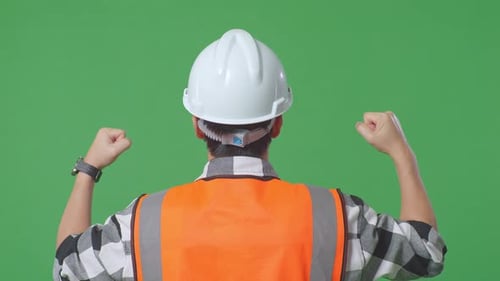 Back View Of A Male Engineer Raising His Hands Celebrating While Working In The Green Screen